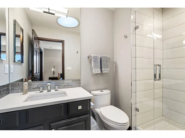 a bathroom with a sink vanity mirror and toilet