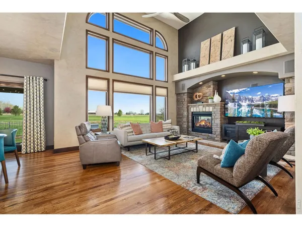 a living room with fireplace furniture and a large window
