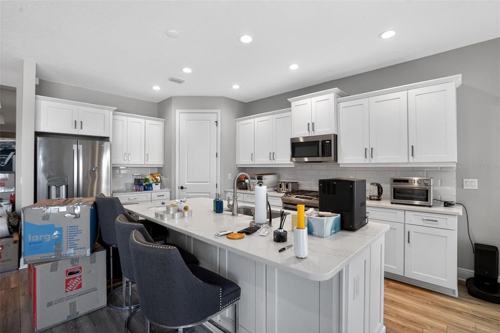 10710 Falling Leaf Court Parrish, FL 34219 - Photo 17 of 50 a kitchen with stainless steel appliances granite countertop a sink a stove a refrigerator cabinets and chairs