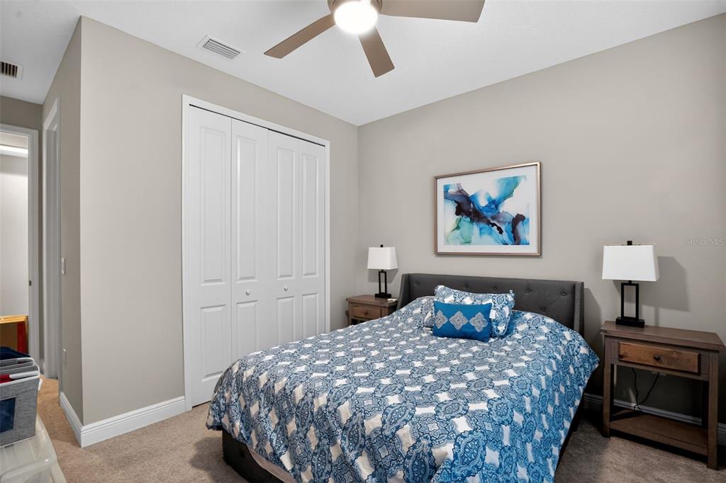 10710 Falling Leaf Court Parrish, FL 34219 - Photo 27 of 50 a bedroom with a bed and a lamp