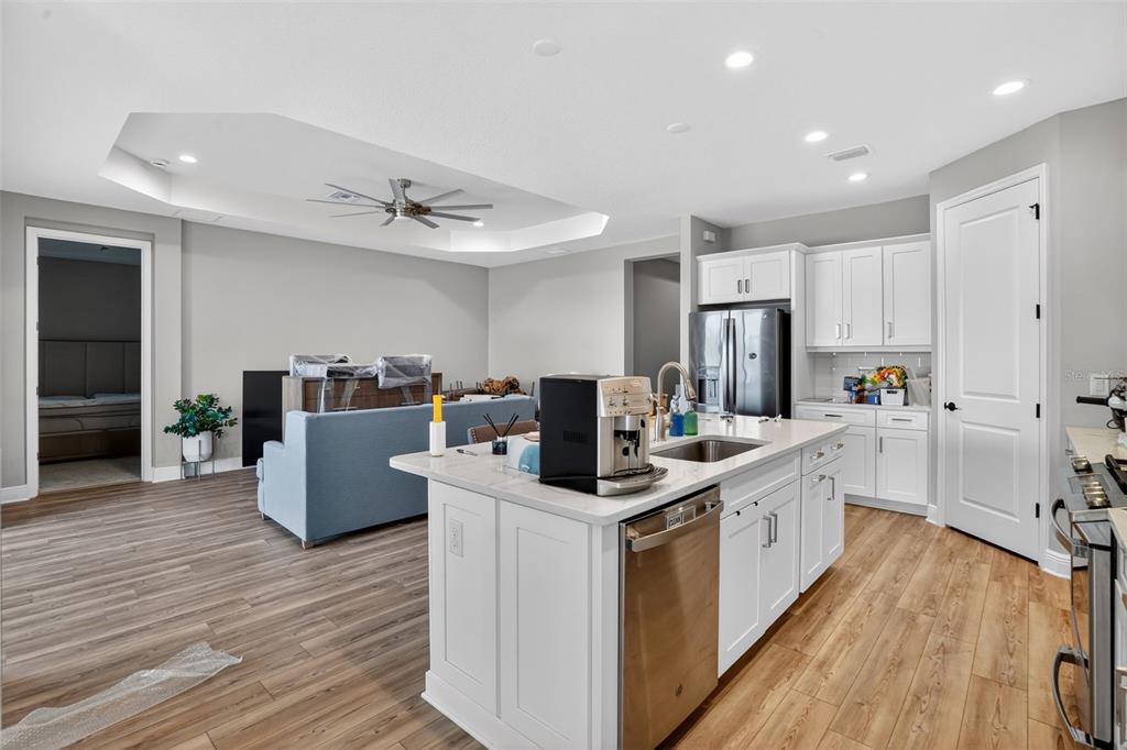 10710 Falling Leaf Court Parrish, FL 34219 - Photo 4 of 50 a kitchen with kitchen island a sink a counter top space stainless steel appliances and cabinets