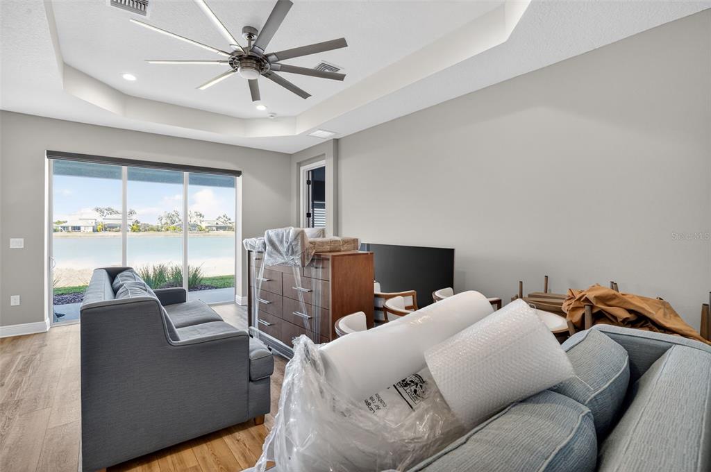 10710 Falling Leaf Court Parrish, FL 34219 - Photo 8 of 50 a living room with furniture a large window and a chandelier