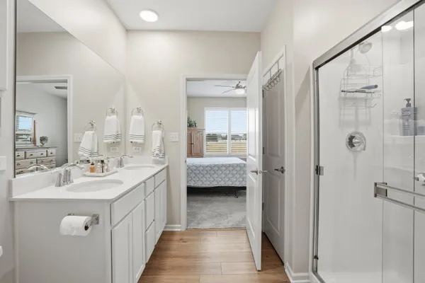 a en suite bathroom with a double vanity sink a mirror and a shower