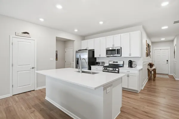 a kitchen with white cabinets and stainless steel appliances