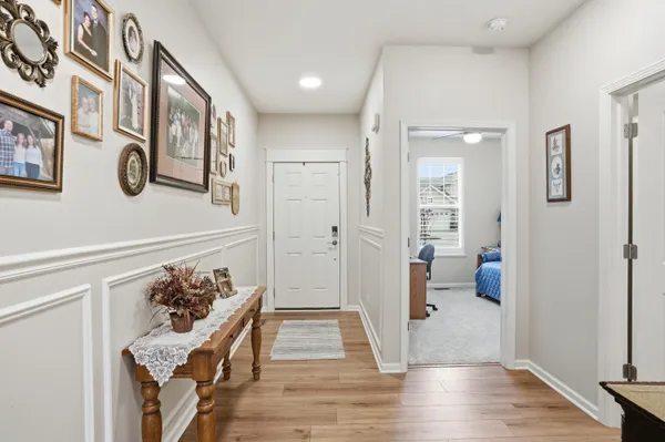 a view of a hallway with wooden floor and a living room