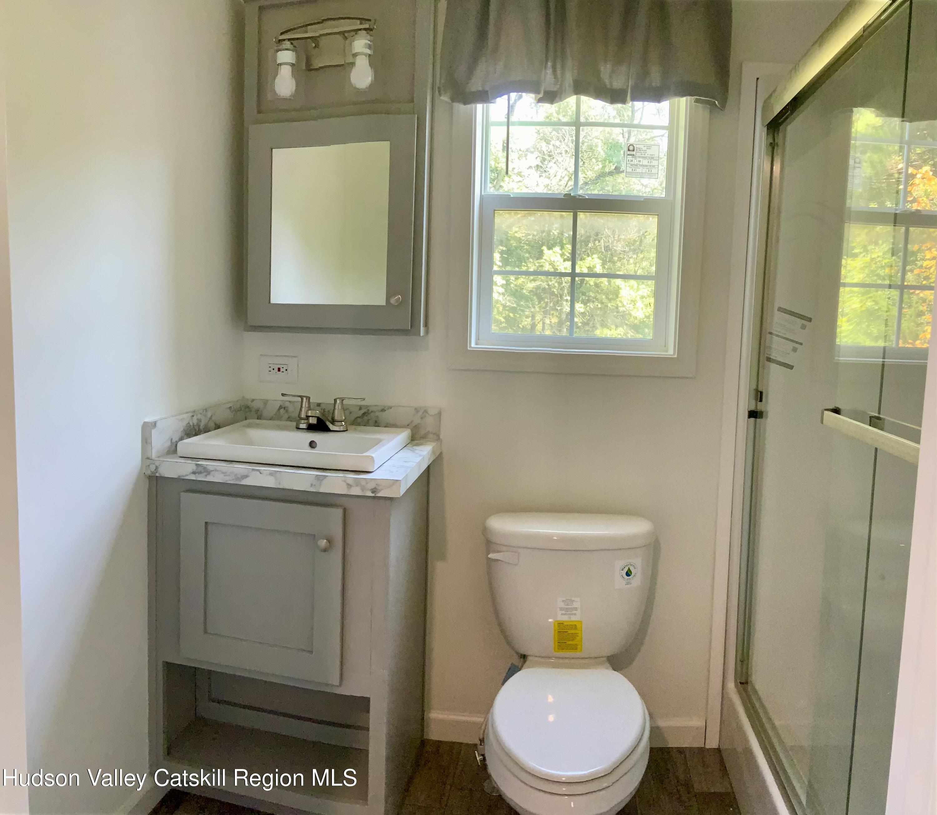 1154 Us-9, Unit 27 Hudson, NY 12534 - Photo 14 of 22 a bathroom with a sink a toilet and a mirror