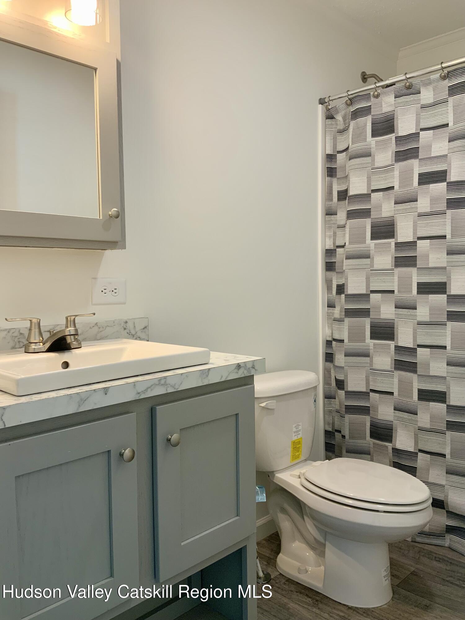 1154 Us-9, Unit 27 Hudson, NY 12534 - Photo 20 of 22 a bathroom with a granite countertop toilet a sink and a mirror
