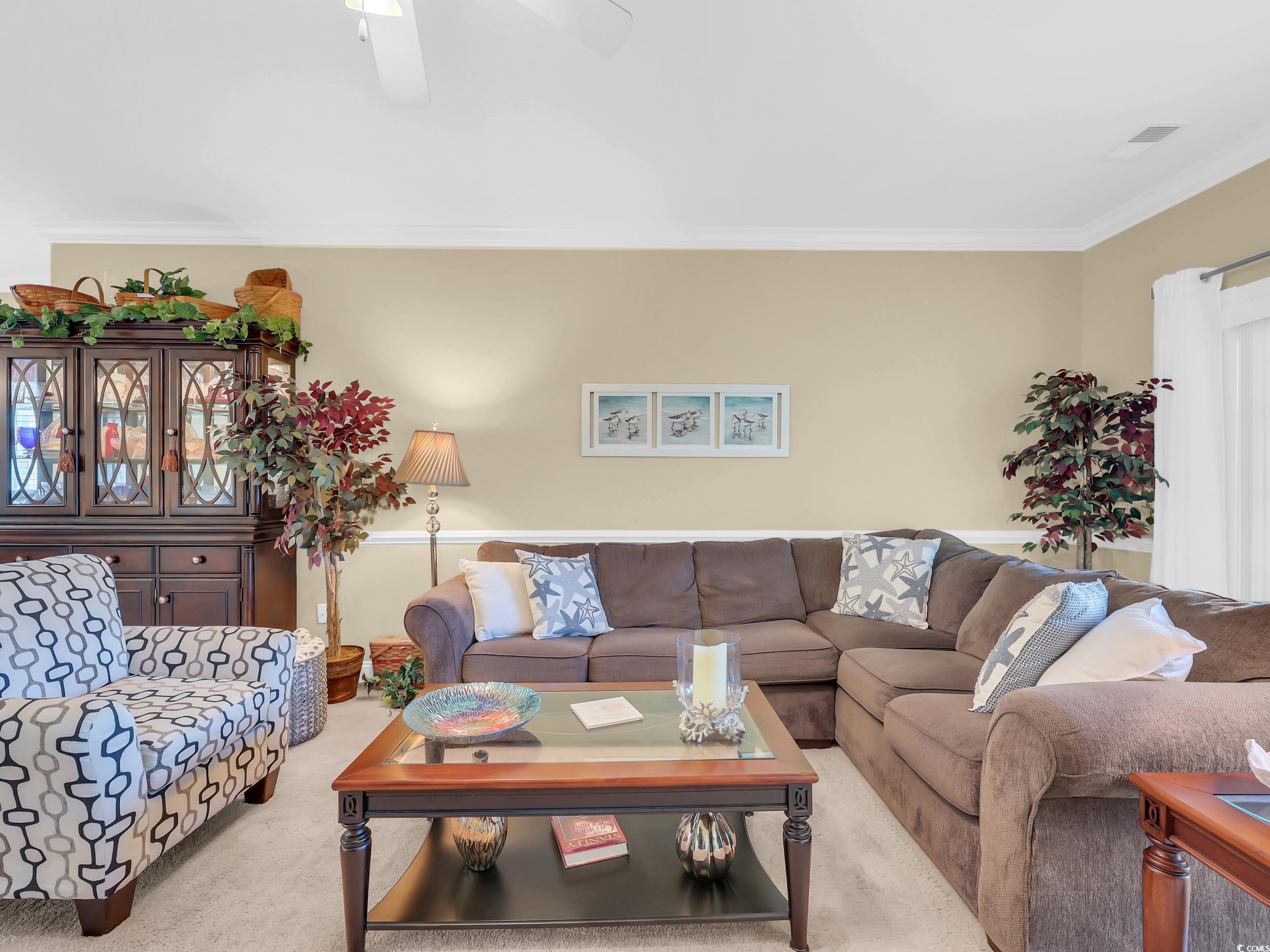 4833 Luster Leaf Circle, Unit 201 Myrtle Beach, SC 29577 - Photo 14 of 39 Carpeted living room with crown molding