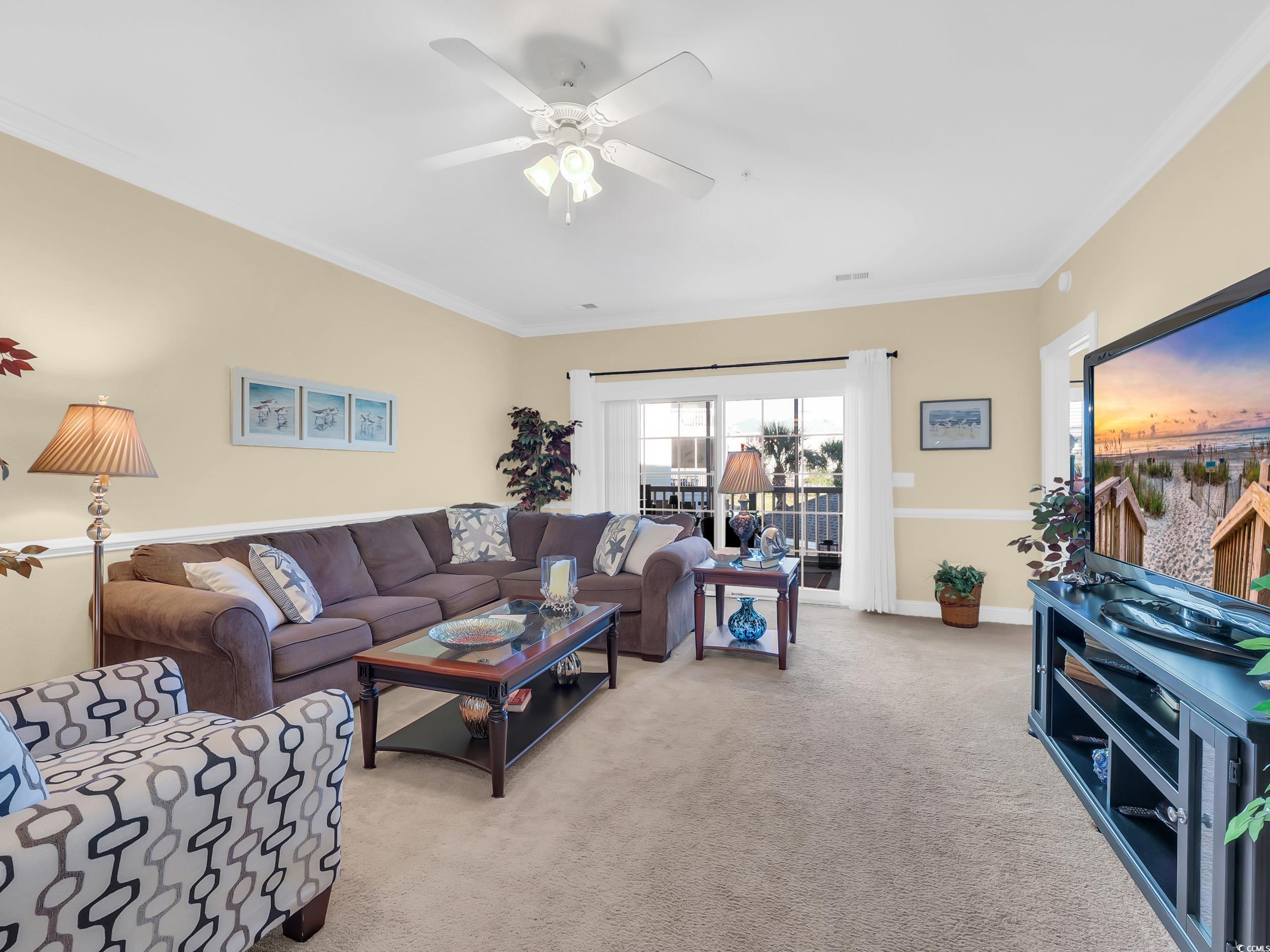 4833 Luster Leaf Circle, Unit 201 Myrtle Beach, SC 29577 - Photo 15 of 39 Carpeted living room featuring ornamental molding and ceiling fan