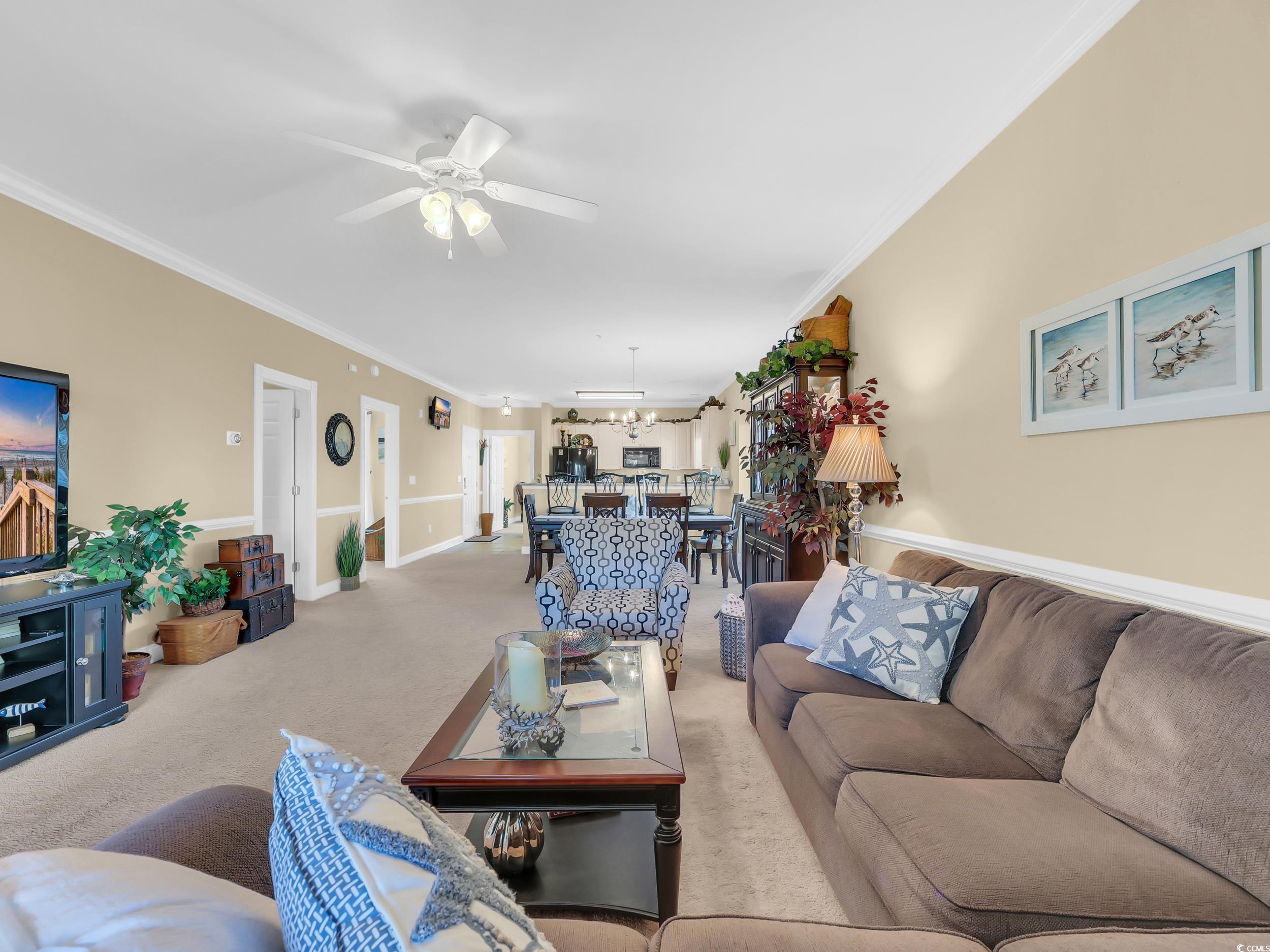 4833 Luster Leaf Circle, Unit 201 Myrtle Beach, SC 29577 - Photo 16 of 39 Living room with ornamental molding, carpet floors, and ceiling fan