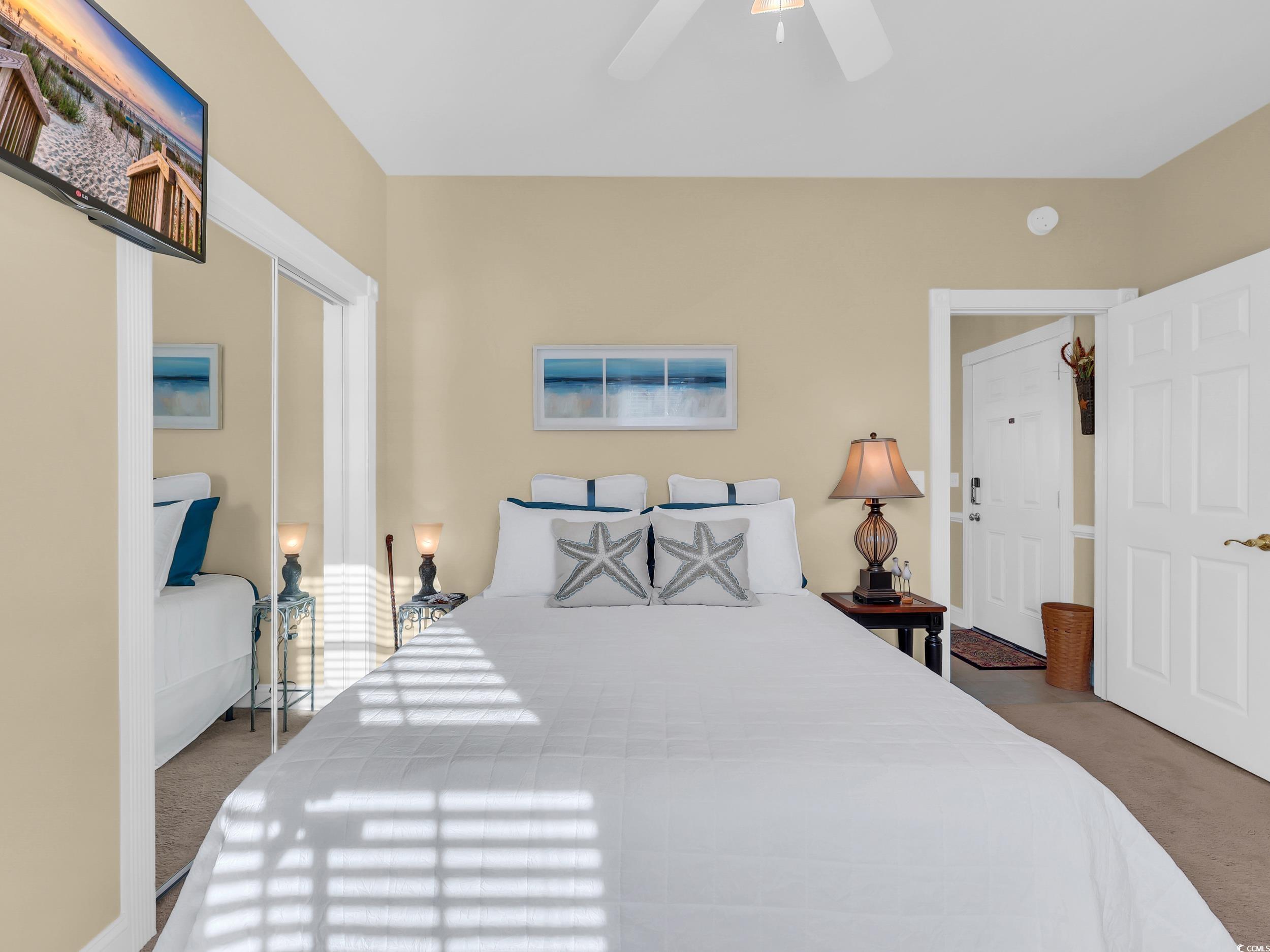 4833 Luster Leaf Circle, Unit 201 Myrtle Beach, SC 29577 - Photo 18 of 39 Bedroom with a closet, dark carpet, and ceiling fan