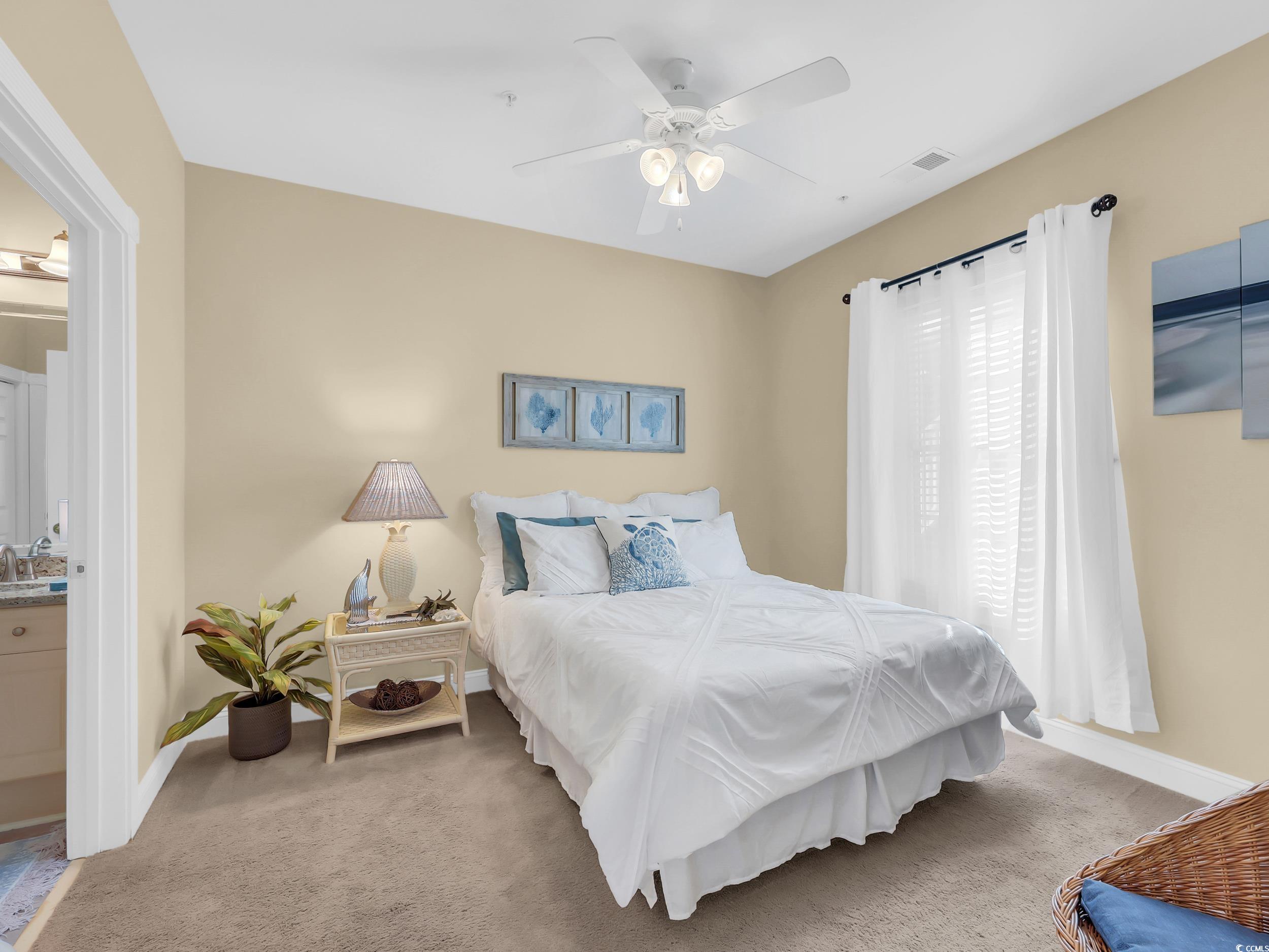 4833 Luster Leaf Circle, Unit 201 Myrtle Beach, SC 29577 - Photo 21 of 39 Carpeted bedroom with ensuite bath and a ceiling fan