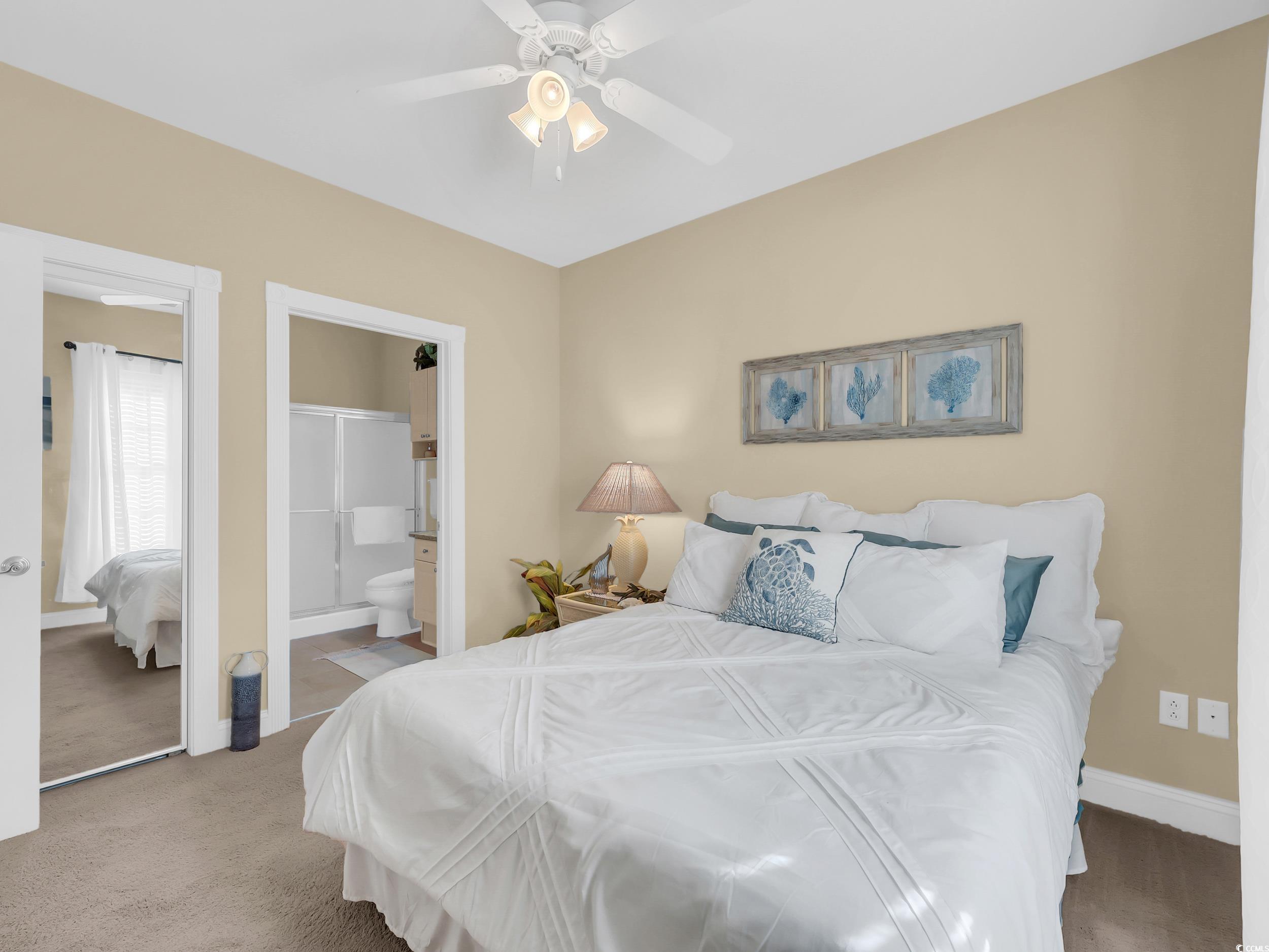 4833 Luster Leaf Circle, Unit 201 Myrtle Beach, SC 29577 - Photo 22 of 39 Carpeted bedroom featuring ceiling fan and ensuite bath