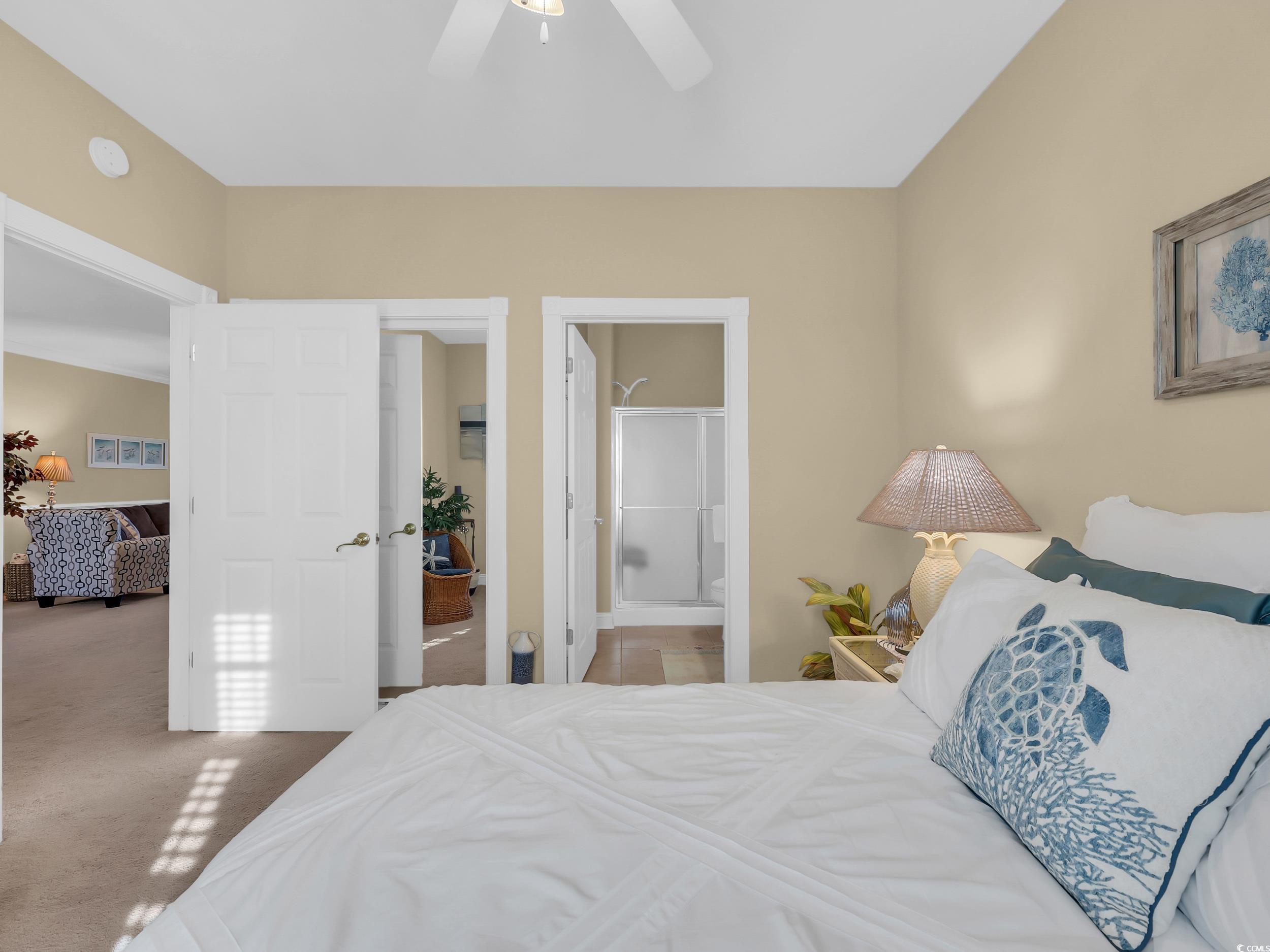 4833 Luster Leaf Circle, Unit 201 Myrtle Beach, SC 29577 - Photo 23 of 39 Carpeted bedroom featuring ensuite bathroom and a ceiling fan