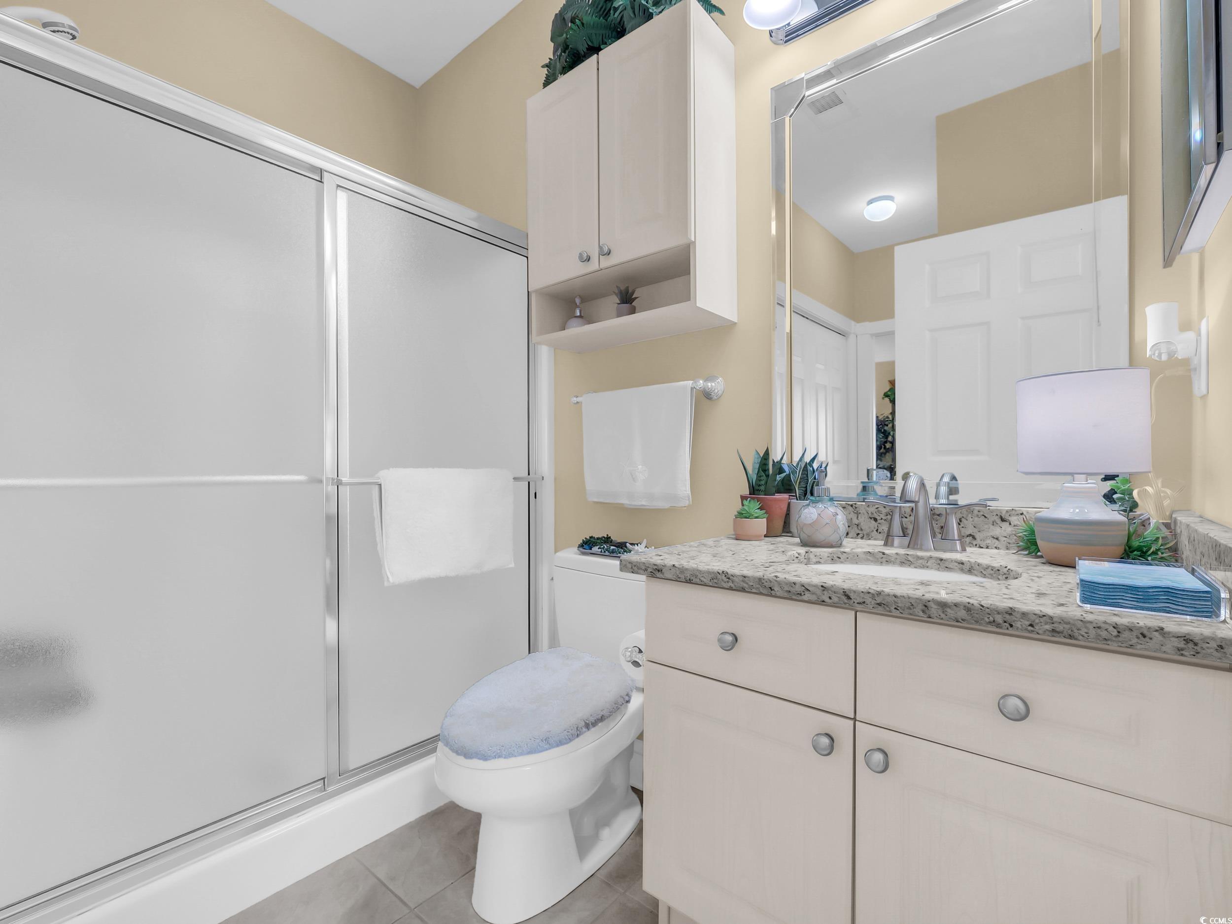 4833 Luster Leaf Circle, Unit 201 Myrtle Beach, SC 29577 - Photo 24 of 39 Full bathroom featuring vanity, a shower stall, and light tile patterned flooring