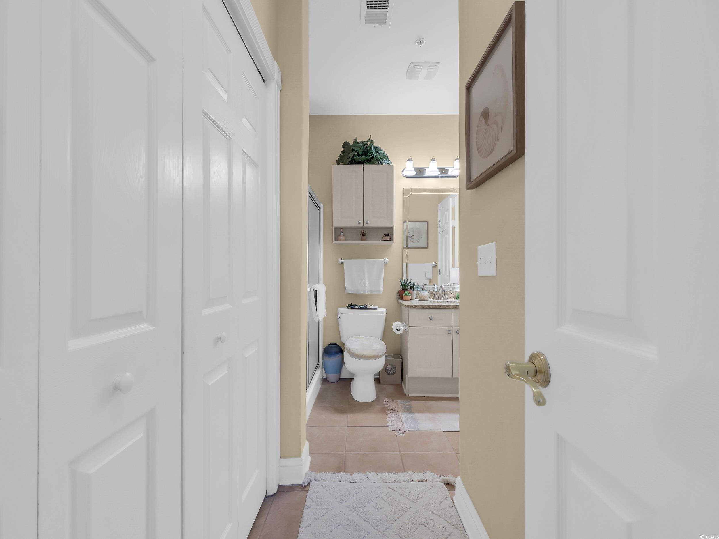4833 Luster Leaf Circle, Unit 201 Myrtle Beach, SC 29577 - Photo 25 of 39 Full bath with vanity, light tile patterned floors, a closet, and a shower stall