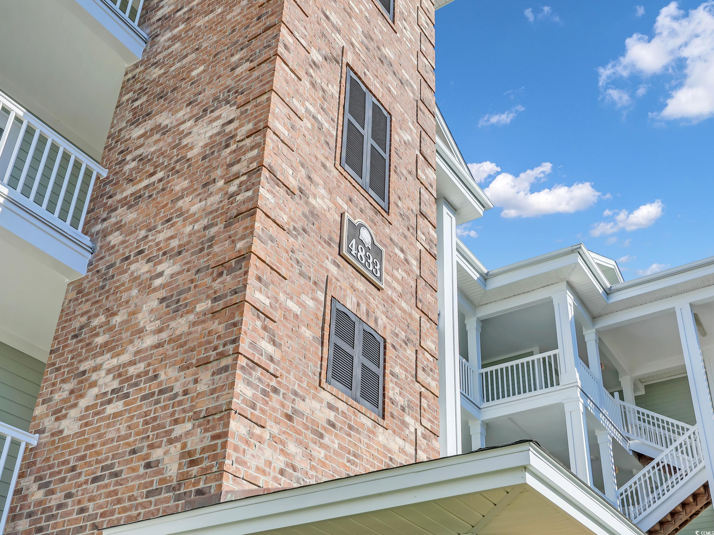 4833 Luster Leaf Circle, Unit 201 Myrtle Beach, SC 29577 - Photo 3 of 39 View of side of property featuring brick siding and a balcony