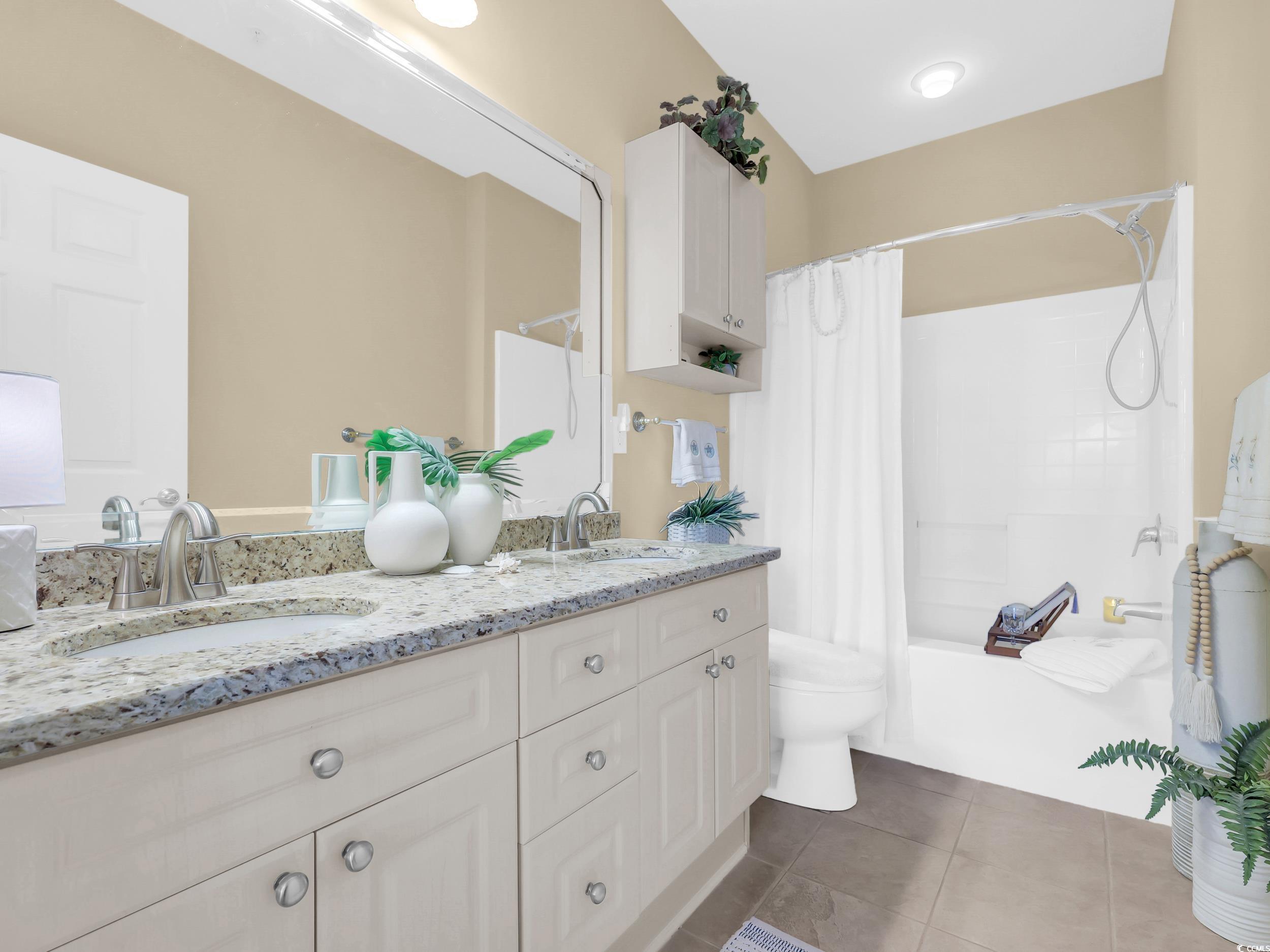 4833 Luster Leaf Circle, Unit 201 Myrtle Beach, SC 29577 - Photo 30 of 39 Full bathroom with double vanity, shower / tub combo with curtain, and dark tile patterned flooring