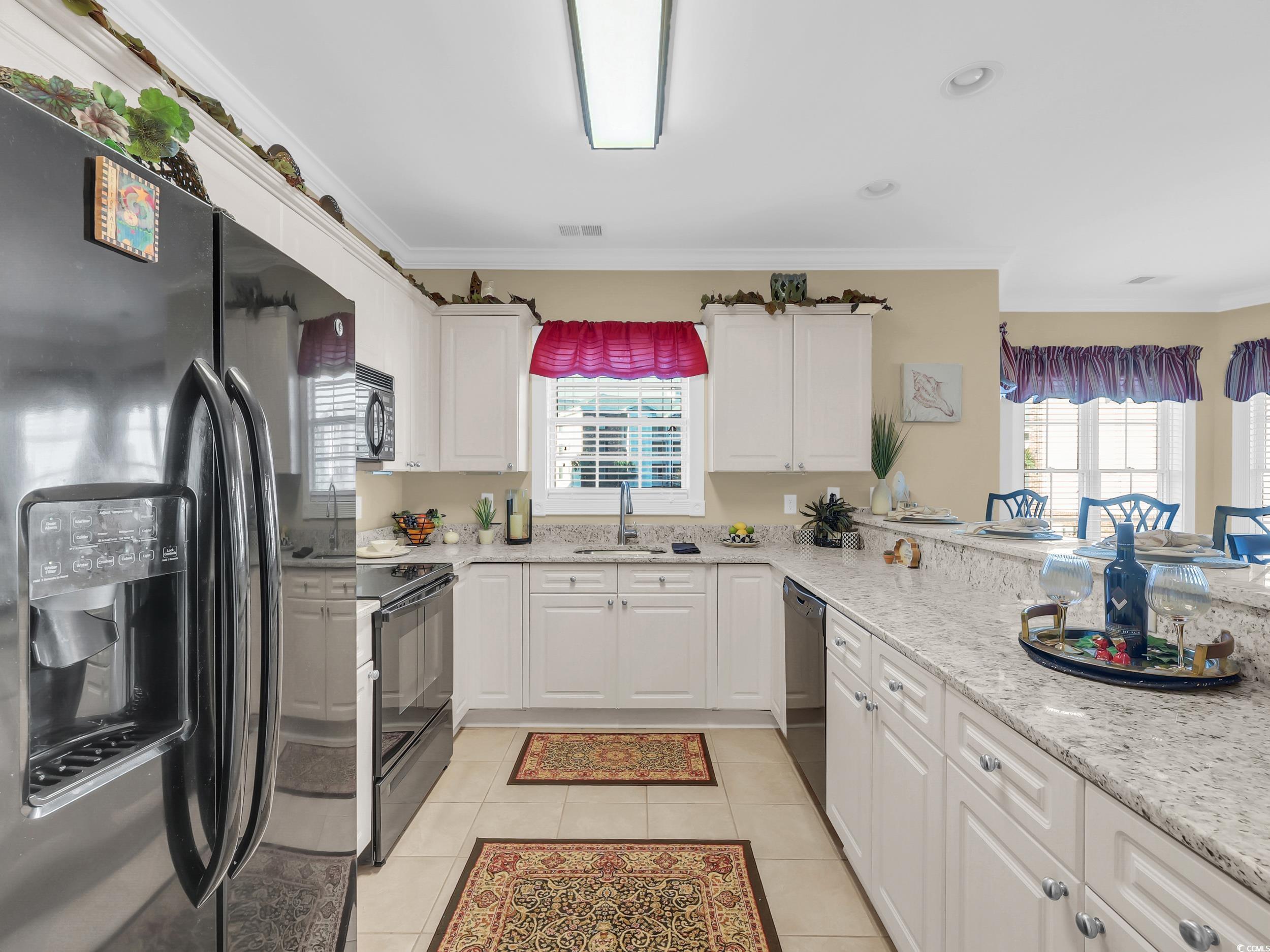 4833 Luster Leaf Circle, Unit 201 Myrtle Beach, SC 29577 - Photo 7 of 39 Kitchen with black appliances, white cabinetry, ornamental molding, light tile patterned flooring, and recessed lighting