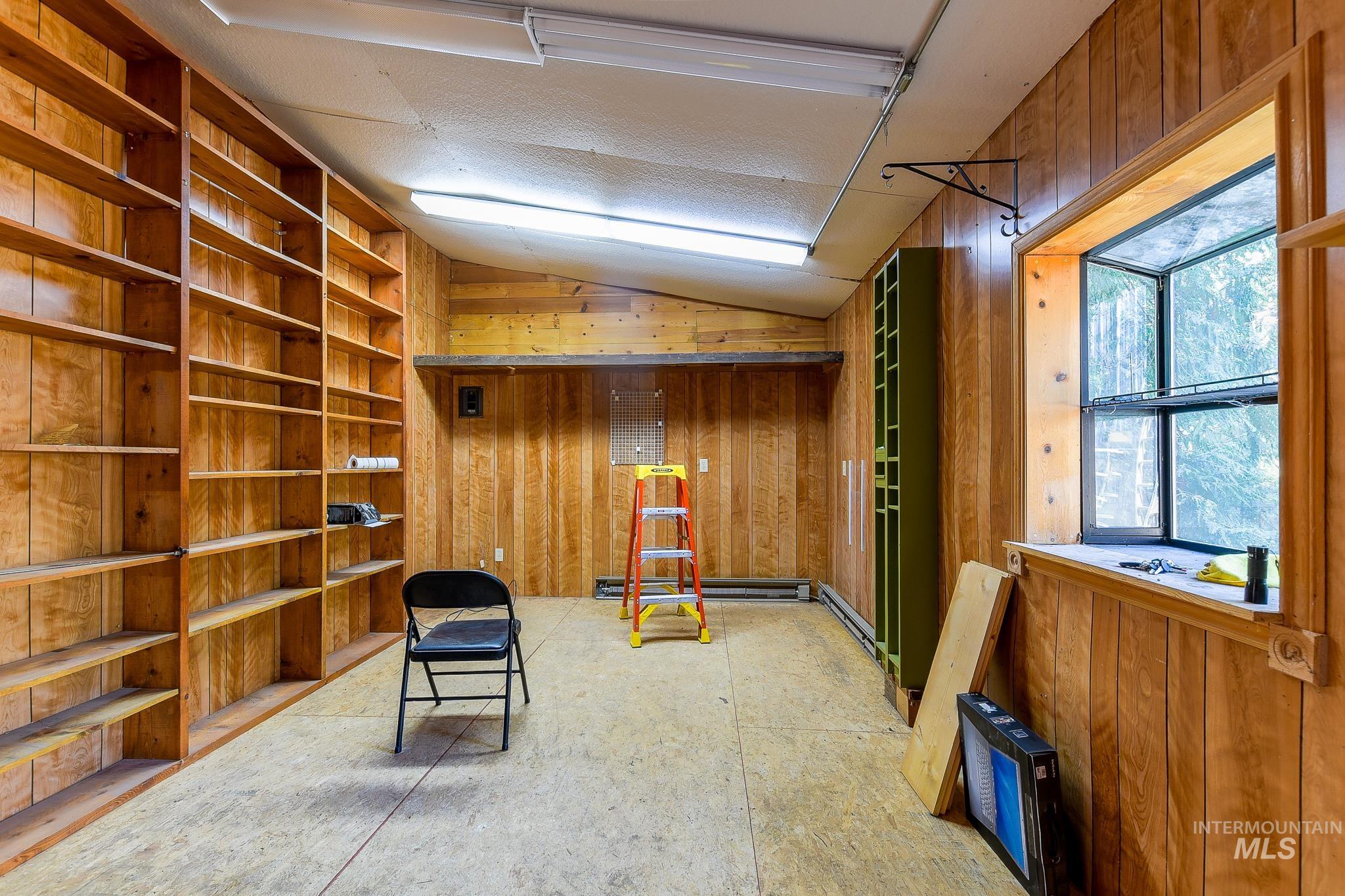 1206 Idlers Rest Road Moscow, ID 83843 - Photo 45 of 47 Built-in wood shelving encompassing an entire wall, with wood-paneled walls and a window offering natural light