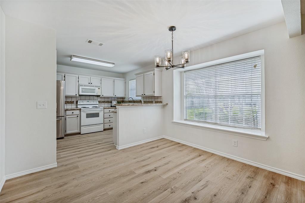 629 Concho Drive Oak Point, TX 75068 - Photo 9 of 35 a kitchen with stainless steel appliances a white cabinets and wooden floor