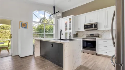a kitchen with granite countertop a stove a sink and a microwave
