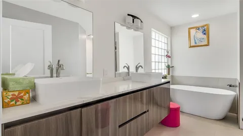 a bathroom with a tub sink and a mirror