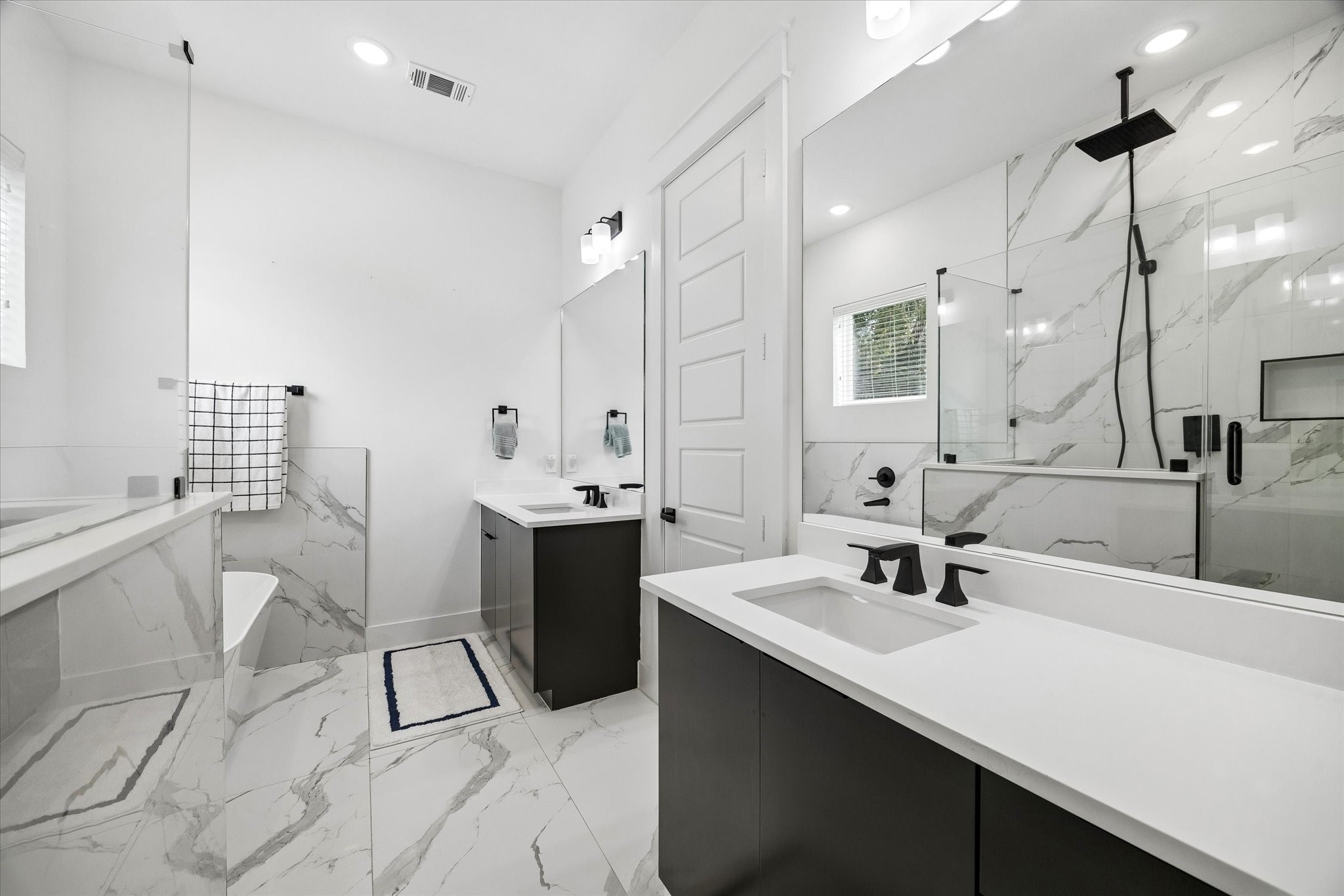 5318 Wunder Lane Houston, TX 77091 - Photo 16 of 25 a bathroom with a double vanity sink a mirror and a bathtub