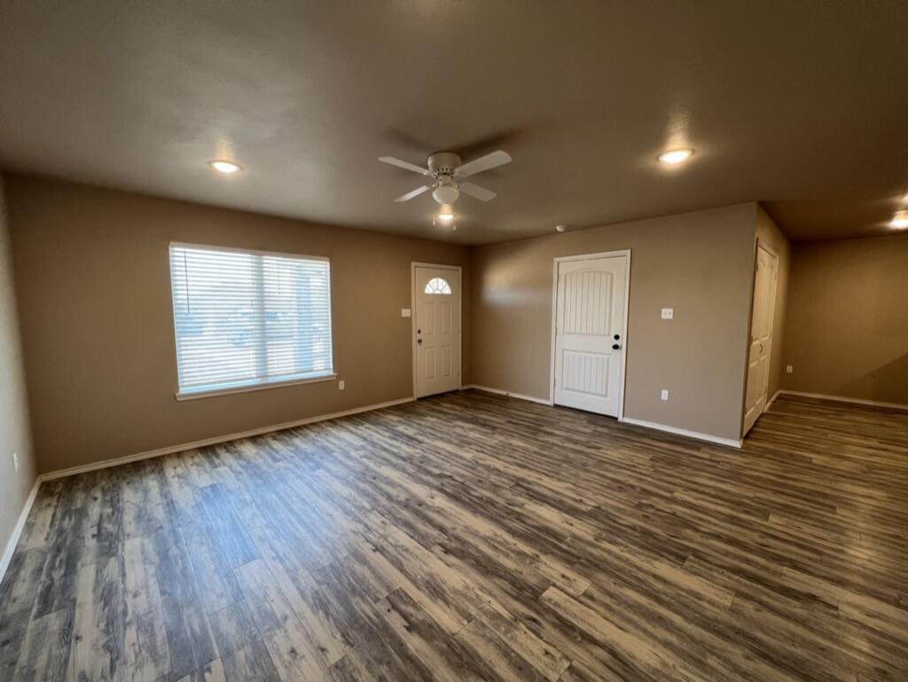 7401 5th Street, Unit 1 Lubbock, TX 79416 - Photo 7 of 19 an empty room with wooden floor and windows