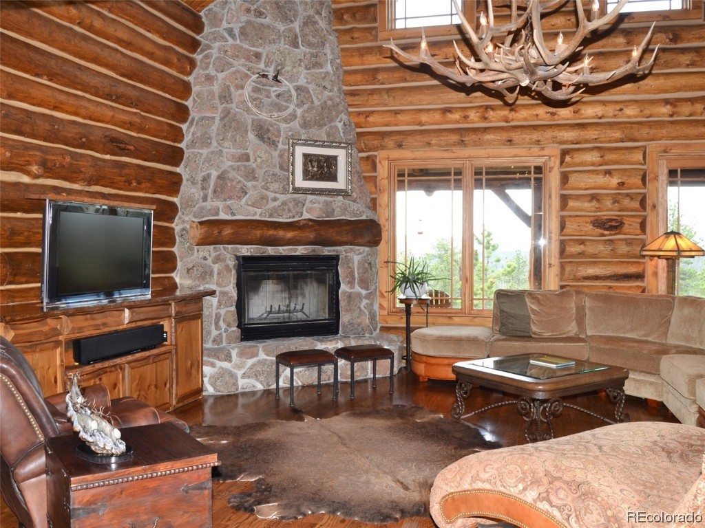 376 Deer Crossing Road Tie Siding, WY 82084 - Photo 3 of 28 a living room with furniture a flat screen tv and a fireplace
