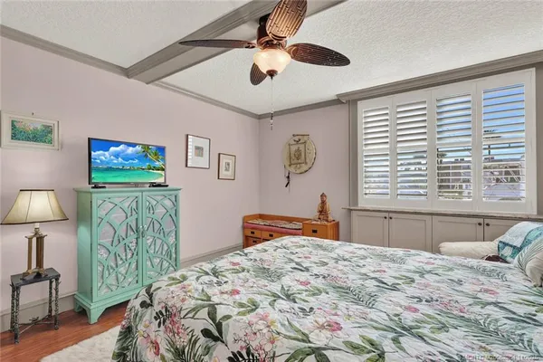 a bedroom with a bed and a large mirror on the dresser