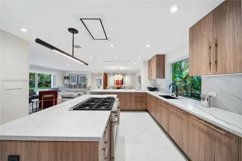 a kitchen that has a lot of cabinets in it and wooden floors