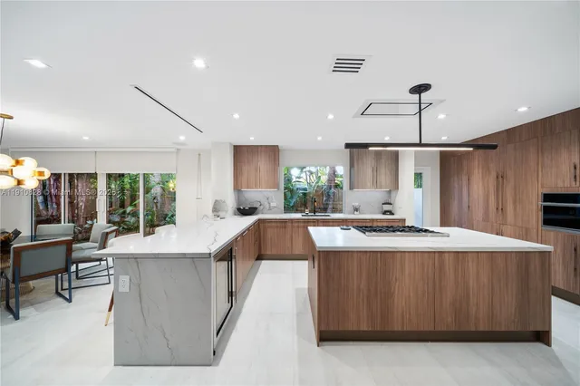 a large kitchen with kitchen island a table and chairs