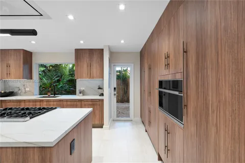 a kitchen with a dining table chairs and living room view