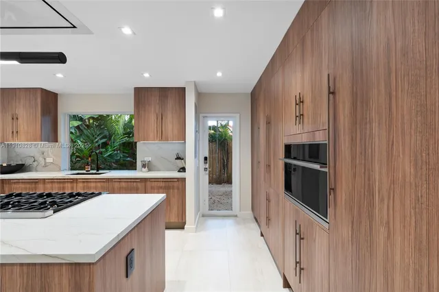 a kitchen with a dining table chairs and living room view