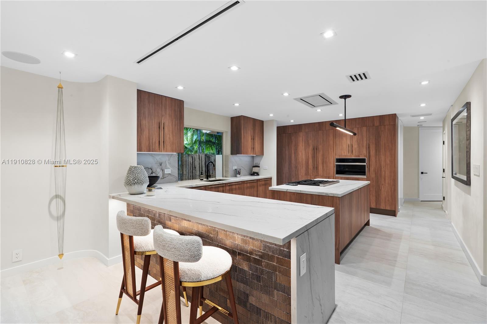 1075 Northeast 99th Street Miami Shores, FL 33138 - Photo 19 of 63 a large kitchen with kitchen island a table and chairs
