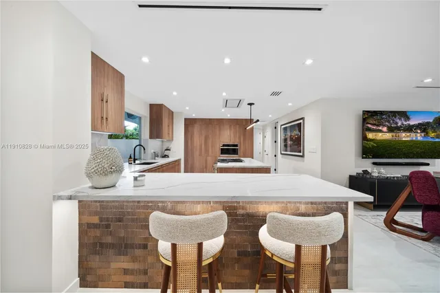 a kitchen with stainless steel appliances a sink a stove a refrigerator and cabinets