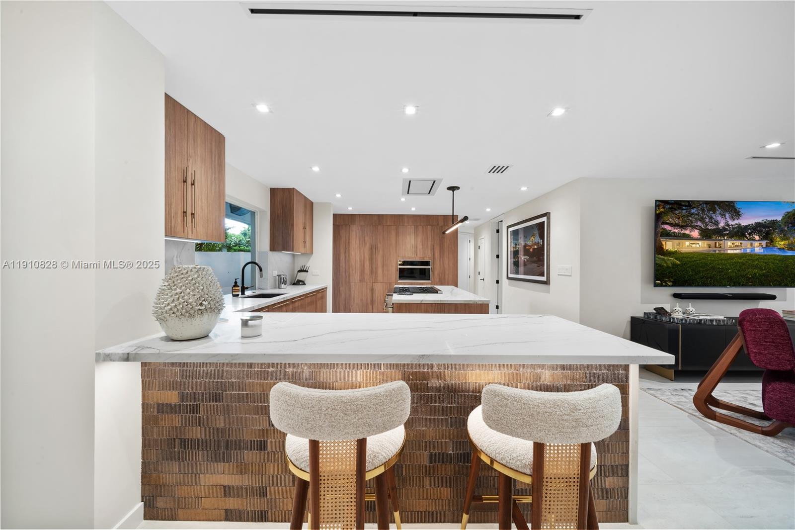 1075 Northeast 99th Street Miami Shores, FL 33138 - Photo 20 of 63 a kitchen with a dining table chairs and living room view