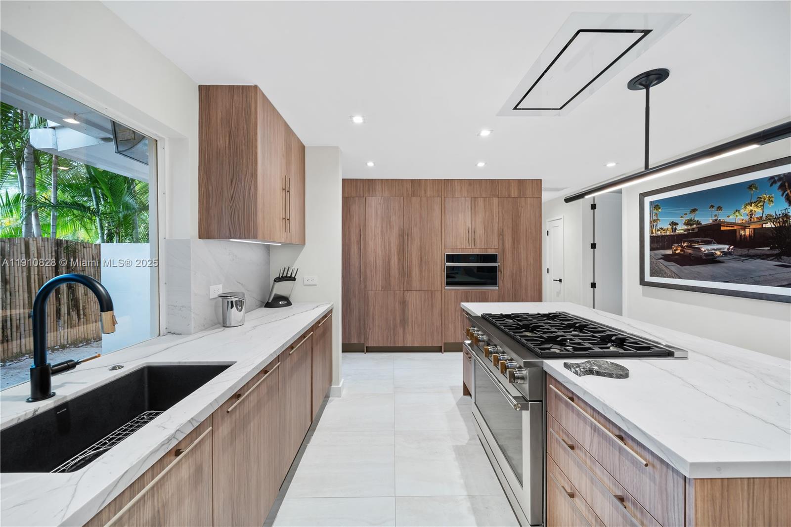 1075 Northeast 99th Street Miami Shores, FL 33138 - Photo 21 of 63 a kitchen with stainless steel appliances granite countertop a sink stove and refrigerator