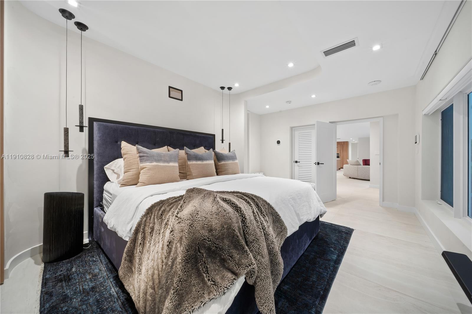 1075 Northeast 99th Street Miami Shores, FL 33138 - Photo 26 of 63 a spacious bedroom with a bed and a large mirror