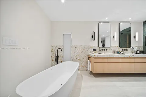 a bathroom with a tub sink and mirror