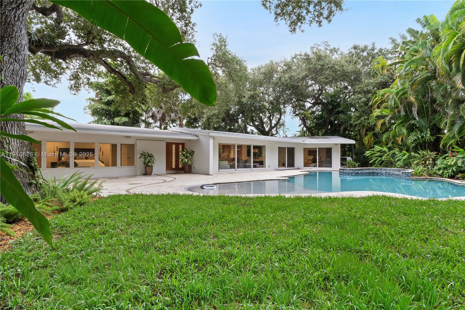 1075 Northeast 99th Street Miami Shores, FL 33138 - Photo 40 of 63 a front view of a house with a garden