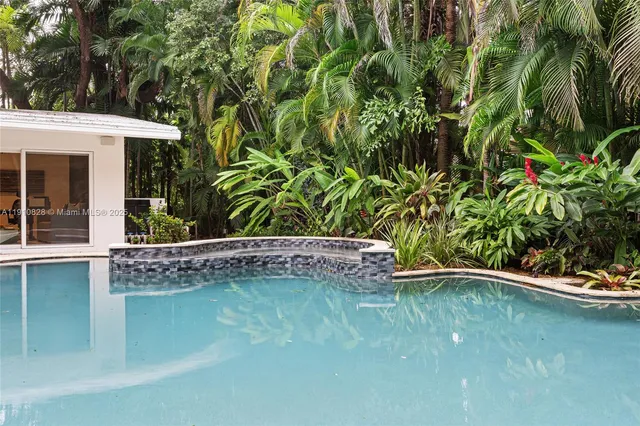 a view of a house with backyard and trees
