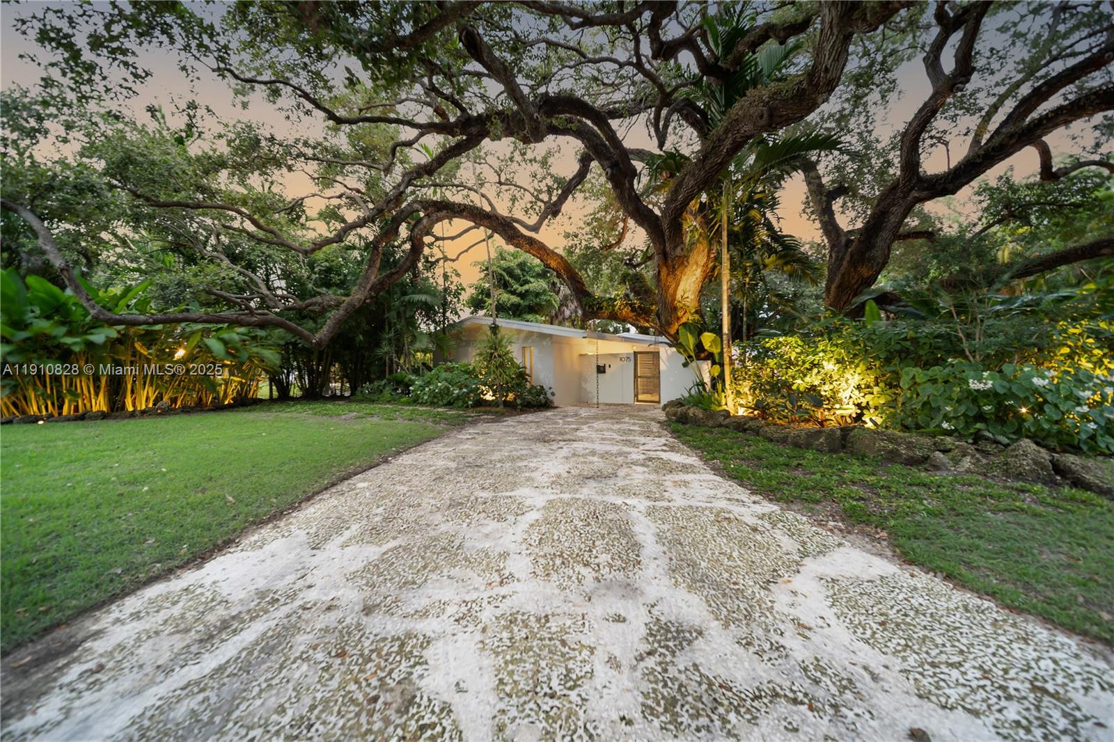 1075 Northeast 99th Street Miami Shores, FL 33138 - Photo 43 of 63 a view of a yard with plants and a large tree