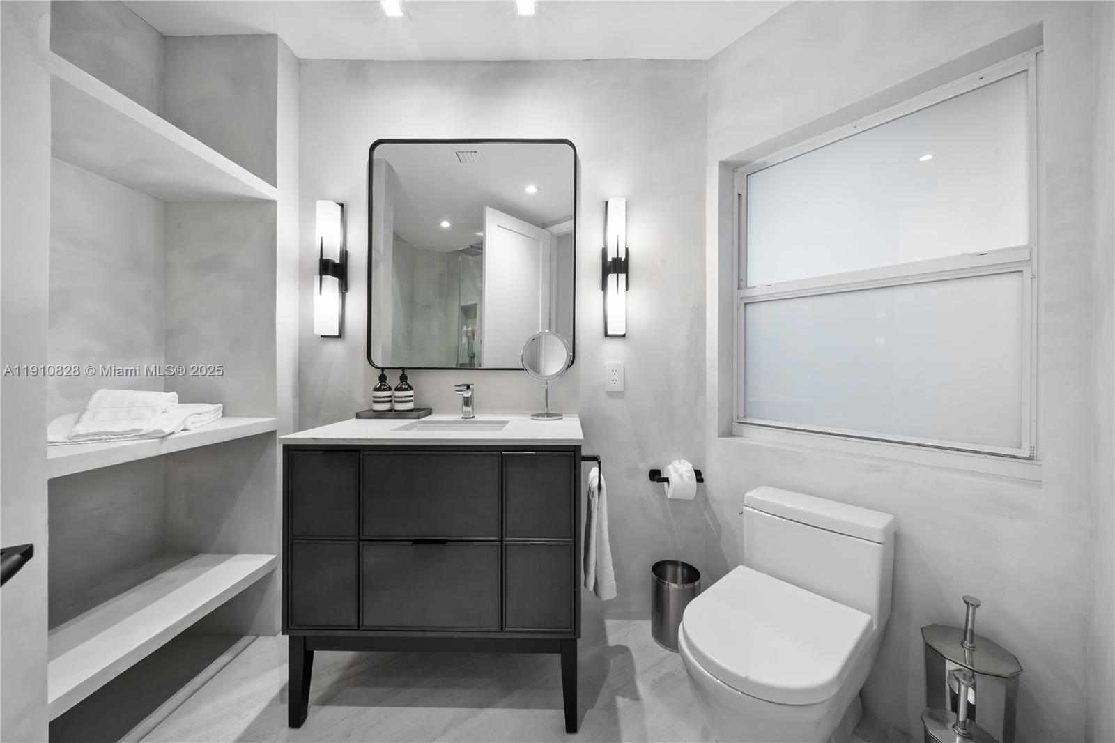 1075 Northeast 99th Street Miami Shores, FL 33138 - Photo 61 of 63 a bathroom with a toilet sink and mirror