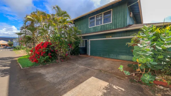 a view of a house with a yard and potted plants