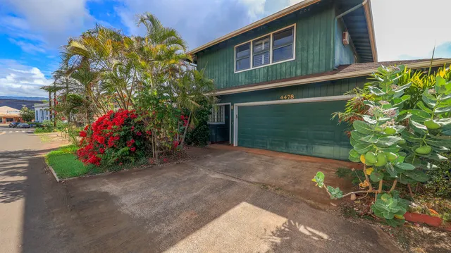 a view of a house with a yard and potted plants