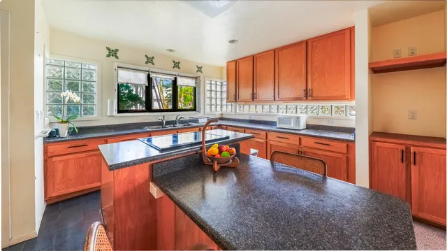 a kitchen with stainless steel appliances granite countertop sink stove and wooden floor