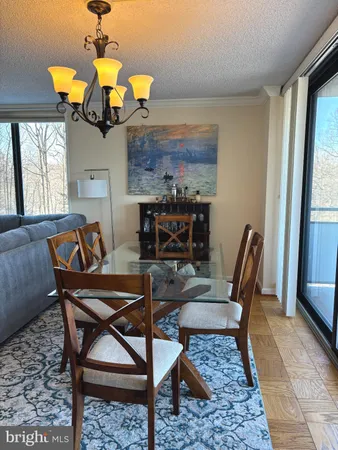 a living room with furniture a fireplace a chandelier and a large window