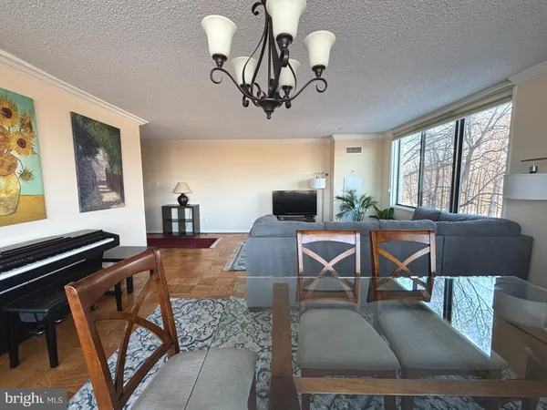 a view of a dining room with furniture a livingroom and chandelier